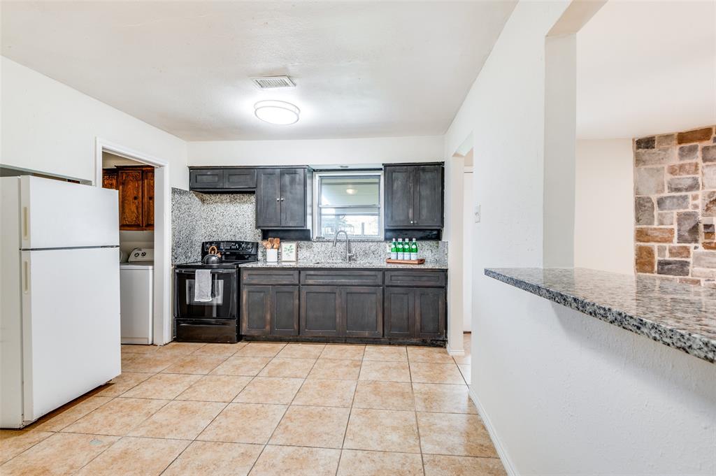 1805 Etain Road Irving, TX 75060 - Photo 5 of 23 a kitchen with granite countertop a refrigerator and a stove top oven