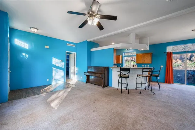 a view of a livingroom with furniture a flat screen tv and kitchen view