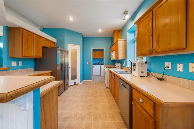 a kitchen with stainless steel appliances granite countertop a stove a sink and a refrigerator