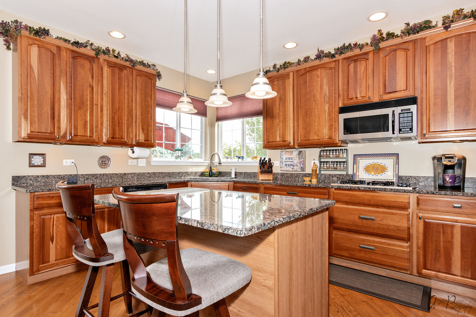 398 Sterling Circle Cary, IL 60013 - Photo 12 of 68 a kitchen with granite countertop a table chairs microwave and cabinets