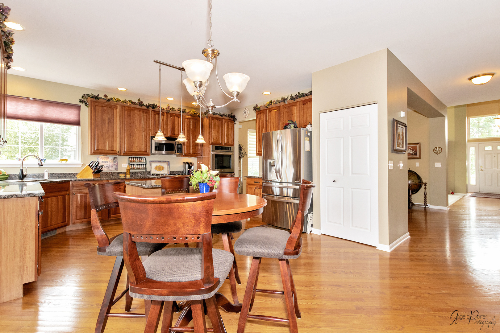 398 Sterling Circle Cary, IL 60013 - Photo 16 of 68 a dining room with granite countertop a table chairs and a kitchen view