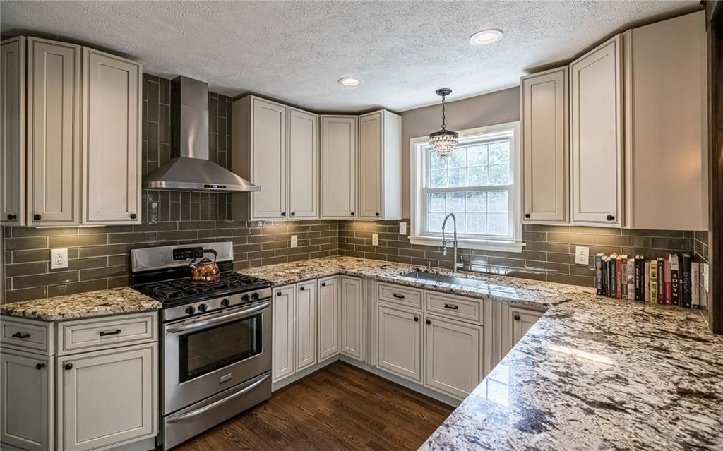 2814 Graham Boulevard Pittsburgh, PA 15235 - Photo 11 of 25 a kitchen with stainless steel appliances granite countertop a stove a sink and a white cabinets