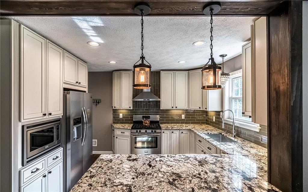 2814 Graham Boulevard Pittsburgh, PA 15235 - Photo 10 of 25 a kitchen with stainless steel appliances granite countertop a sink a stove a refrigerator cabinets and a dining table