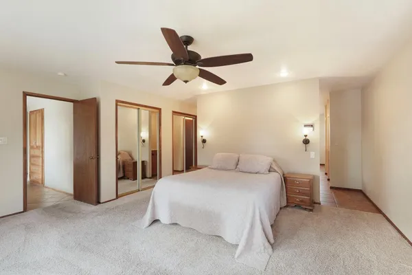 a bedroom with a bed and a ceiling fan