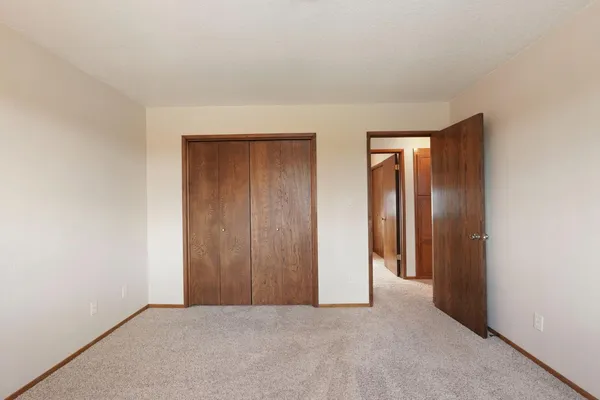 an empty room with closet and a window