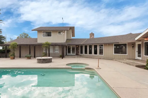 a view of a house with swimming pool and sitting area