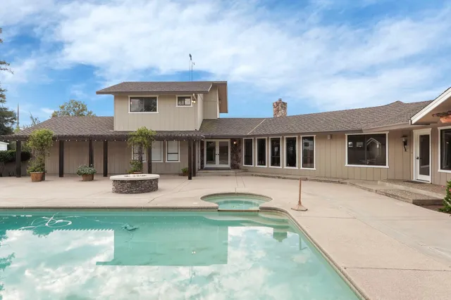 a view of a house with swimming pool and sitting area