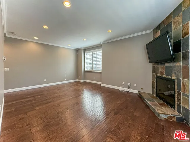 an empty room with wooden floor and fireplace
