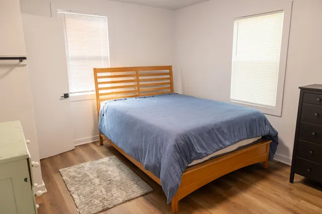 a bedroom with a bed and wooden floor