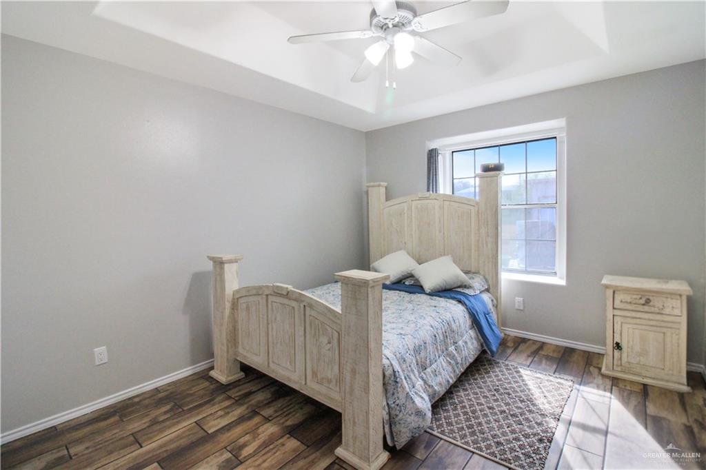 21412 Rusty Lane Harlingen, TX 78552 - Photo 19 of 35 a bedroom with a bed and wooden floor