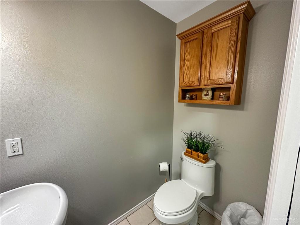 21412 Rusty Lane Harlingen, TX 78552 - Photo 23 of 35 a white toilet sitting next to a bathroom sink and vanity