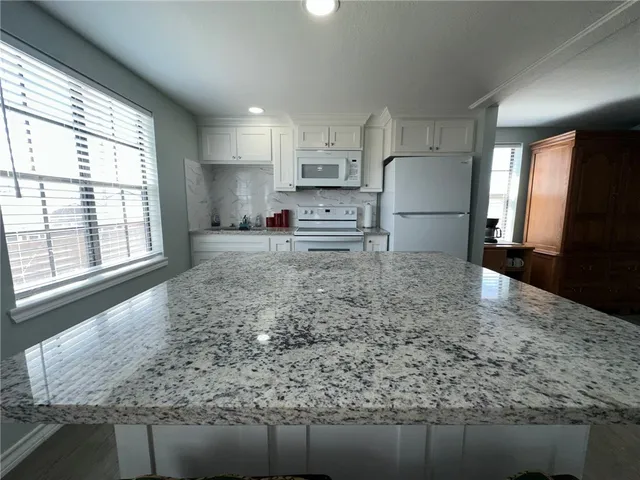 a kitchen with a stove a table and chairs
