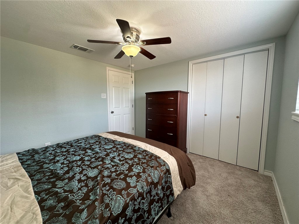 201 Volpe Circle Gregory, TX 78374 - Photo 20 of 29 a bedroom with a bed and a chandelier