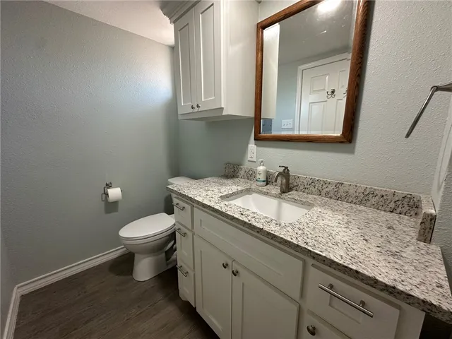 a bathroom with a granite countertop sink a mirror and shower