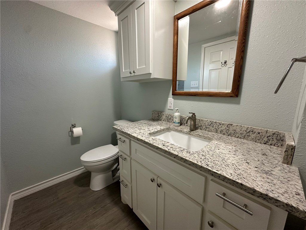 201 Volpe Circle Gregory, TX 78374 - Photo 23 of 29 a bathroom with a granite countertop toilet sink and mirror