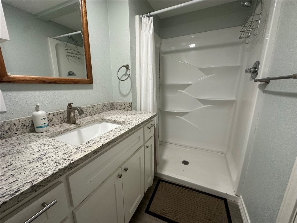 201 Volpe Circle Gregory, TX 78374 - Photo 24 of 29 a bathroom with a granite countertop sink a mirror and shower