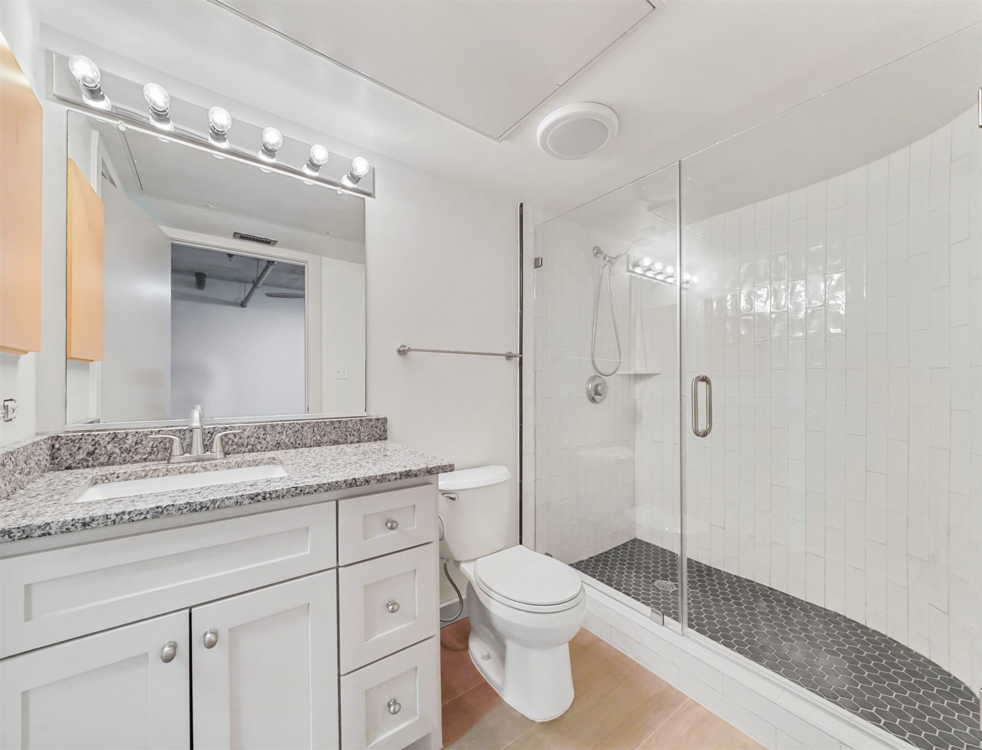 2000 Bagby Street, Unit 5436 Houston, TX 77002 - Photo 15 of 32 a bathroom with a granite countertop sink a toilet and a shower