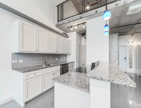 a kitchen with granite countertop a sink stainless steel appliances white cabinets and a granite counter tops