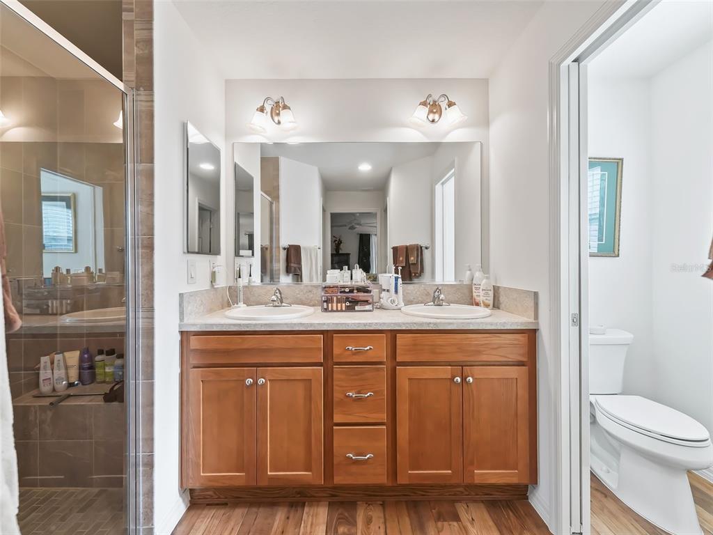 3812 Nottingham Loop The Villages, FL 32163 - Photo 26 of 30 a bathroom with a granite countertop sink a toilet and a mirror