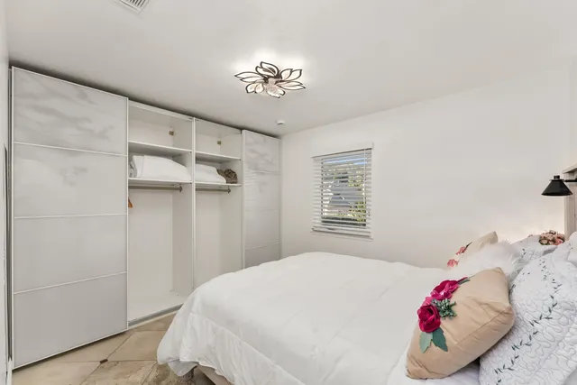 a bedroom with a large bed and a chandelier