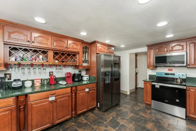 a kitchen with stainless steel appliances granite countertop a refrigerator and a sink