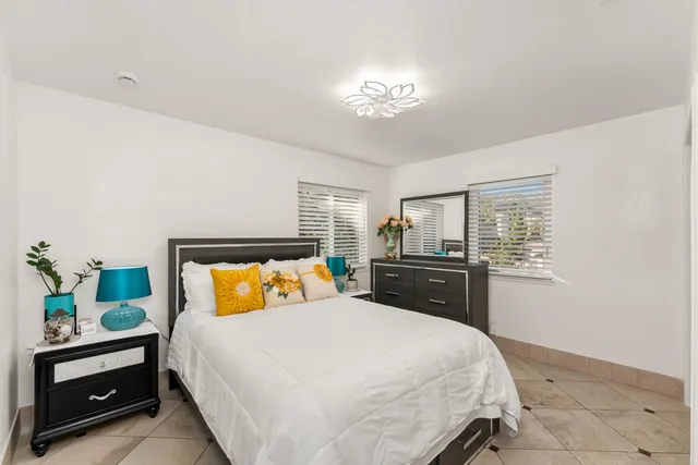 a bedroom with a large bed and a chandelier