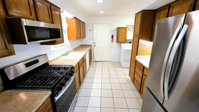 a kitchen with stainless steel appliances a stove microwave and refrigerator