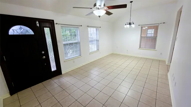 en empty room with windows and fan