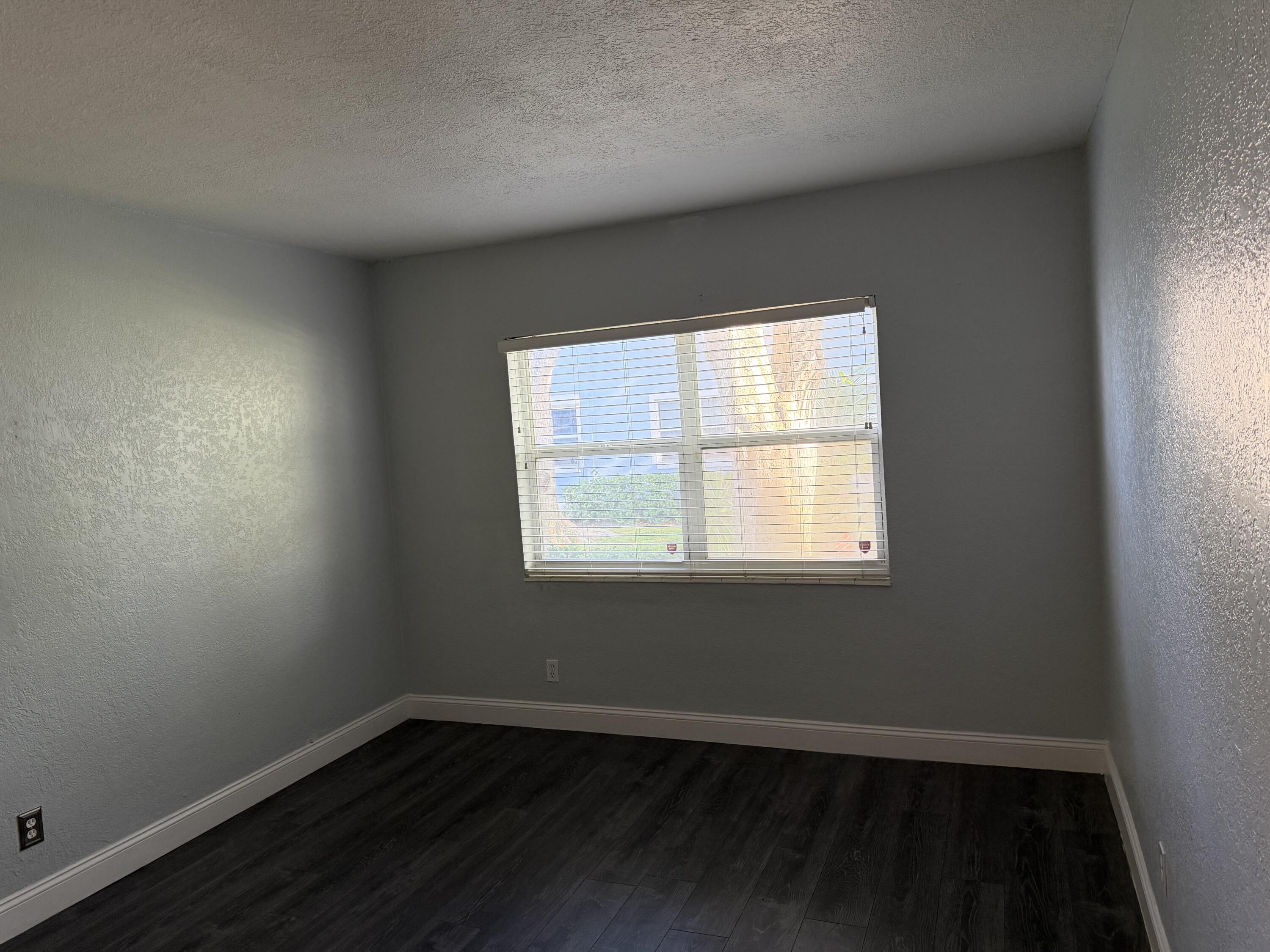 270 South Cypress Road, Unit 204 Pompano Beach, FL 33060 - Photo 6 of 14 an empty room with wooden floor and windows