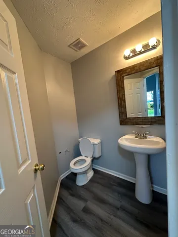 a bathroom with a sink and mirror with toilet