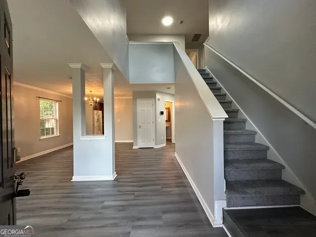 a view of a hallway with wooden floor and staircase