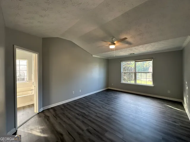 a view of an empty room window and wooden floor