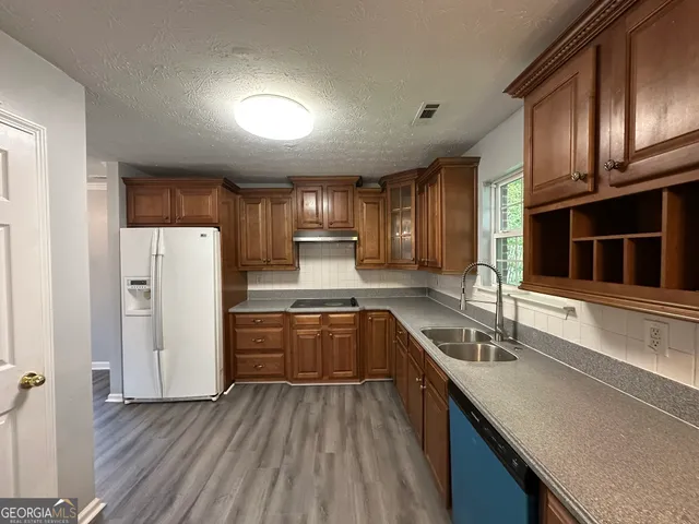 a kitchen with refrigerator cabinets and a sink