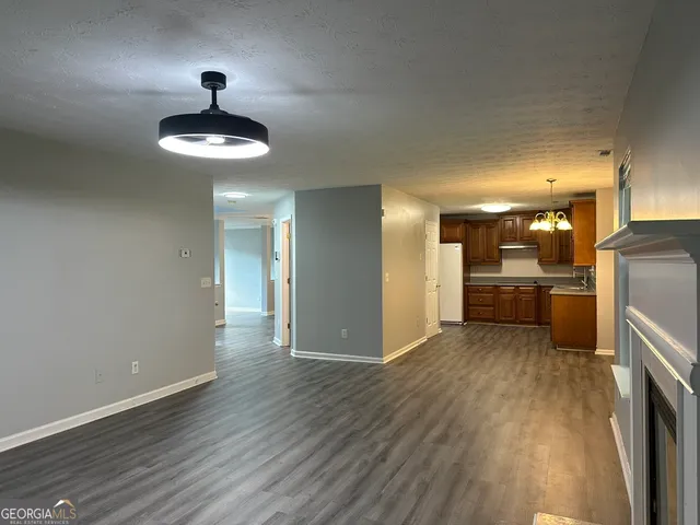 a view of a kitchen with a sink wooden floor a refrigerator and a counter top