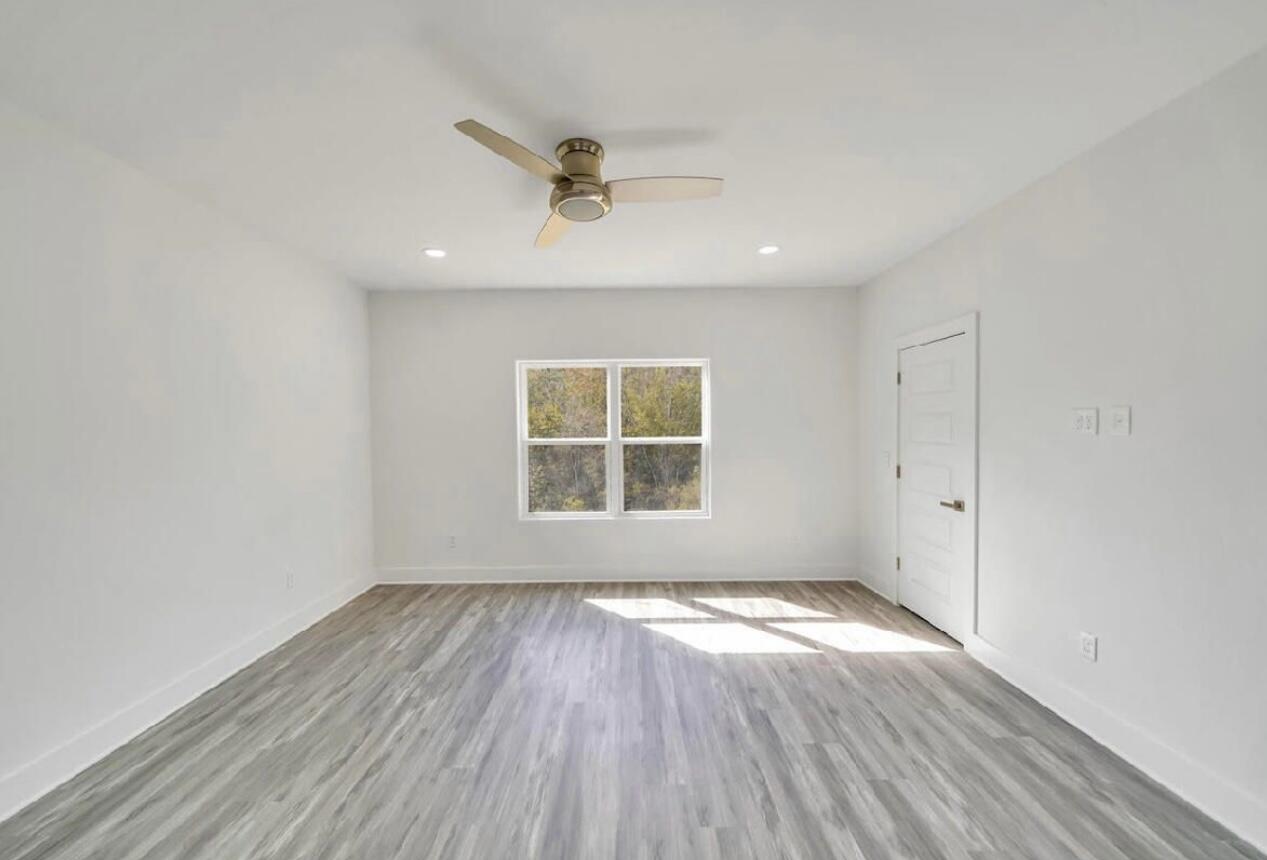 117 Buckeye Street DeFuniak Springs, FL 32433 - Photo 17 of 26 an empty room with wooden floor cabinet and windows