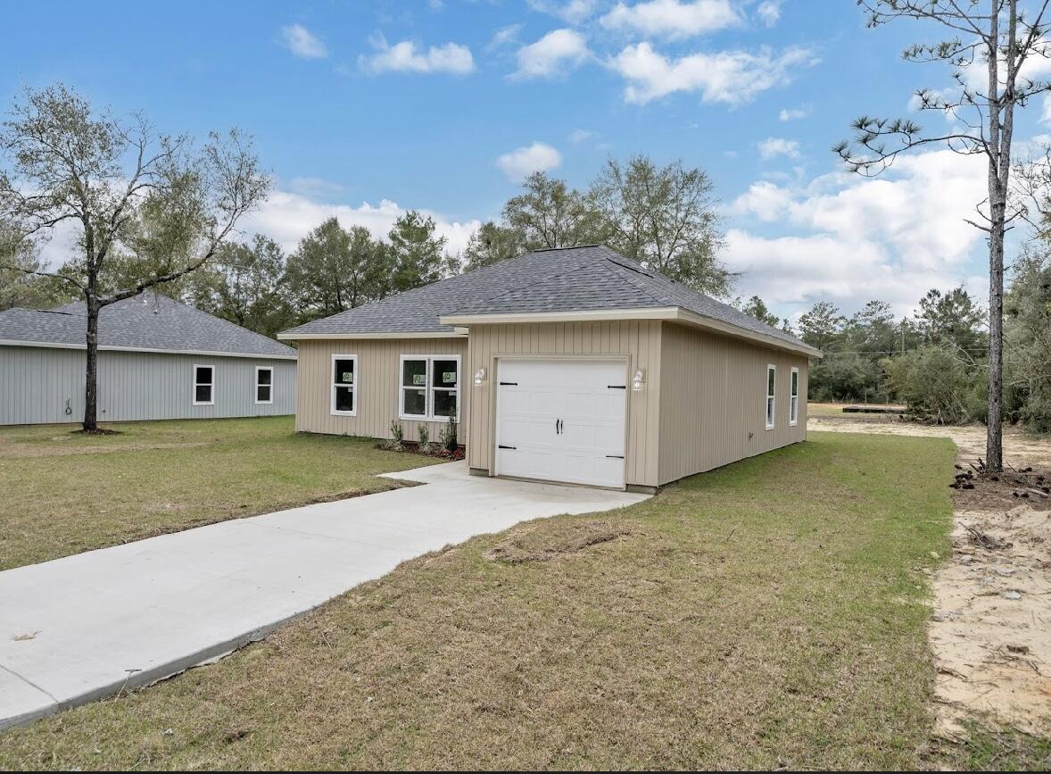 117 Buckeye Street DeFuniak Springs, FL 32433 - Photo 4 of 26 a front view of house with yard and trees in the background