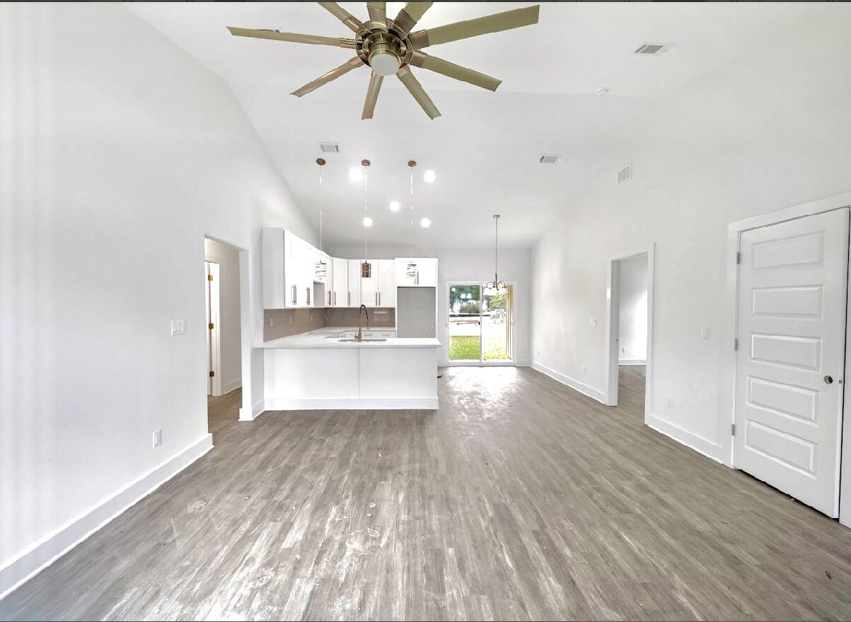 117 Buckeye Street DeFuniak Springs, FL 32433 - Photo 7 of 26 a view of kitchen and hall with wooden floor