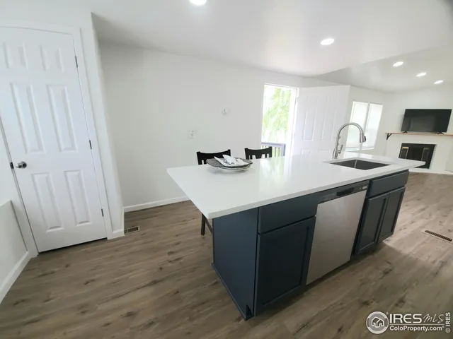 a kitchen with a sink cabinets and wooden floor