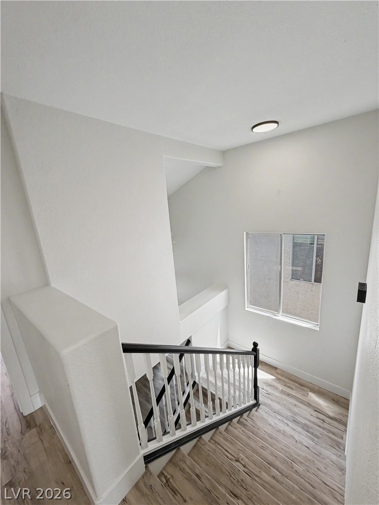 8977 Paige Rene Court Las Vegas, NV 89117 - Photo 26 of 31 Elegant wooden staircase featuring classic white spindles and a striking dark handrail.