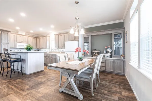 a kitchen with kitchen island a dining table and chairs
