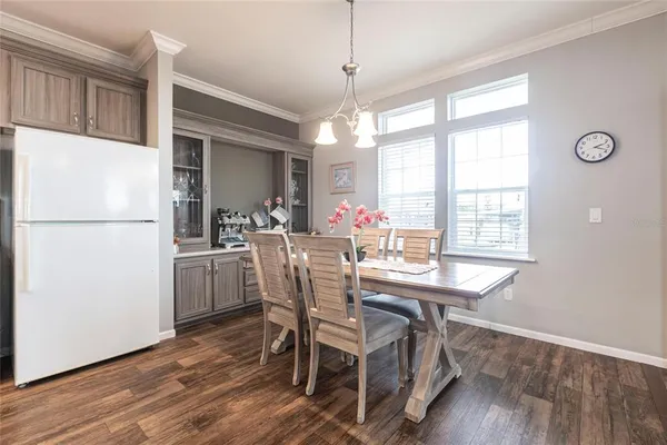 a dining room with furniture a chandelier and wooden floor