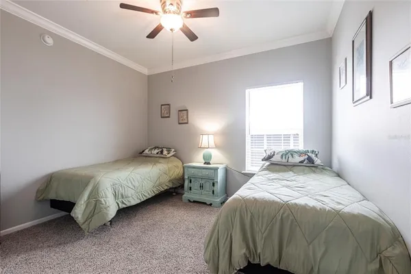 a bedroom with two beds and ceiling fan