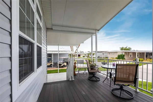 a view of a balcony with chairs and wooden floor