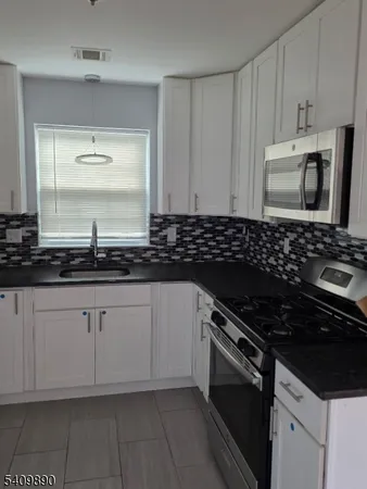 a kitchen with granite countertop a stove and a sink