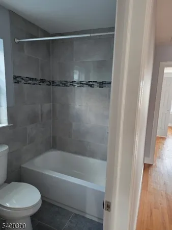 a white toilet sitting next to a bath tub