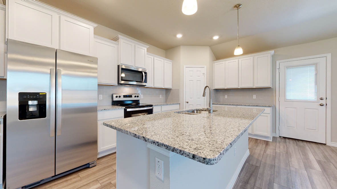 104 Kenzie Street Thorndale, TX 76577 - Photo 3 of 28 a kitchen with granite countertop a refrigerator oven a sink and dishwasher with wooden floor