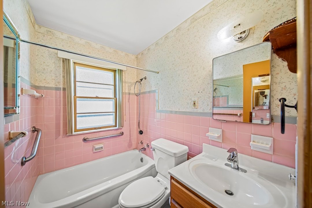 1738 Rockefeller Road Wickliffe, OH 44092 - Photo 24 of 35 Full bathroom featuring tile walls, backsplash, tiled shower / bath combo, vanity, and toilet
