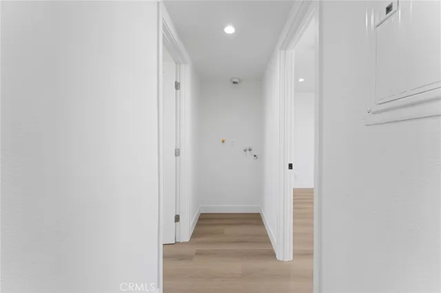 a view of a hallway with wooden floor and staircase