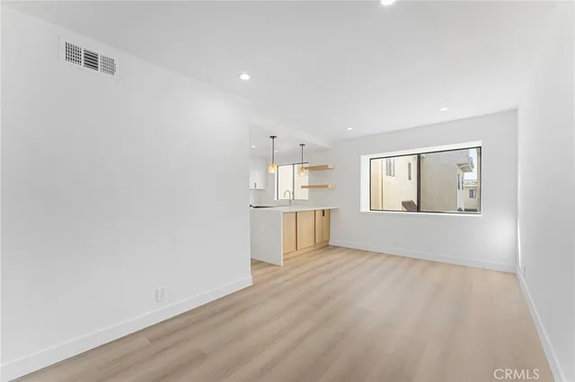 wooden floor in an empty room with a kitchen