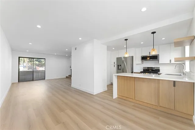 a view of kitchen with kitchen island refrigerator wooden floor and window